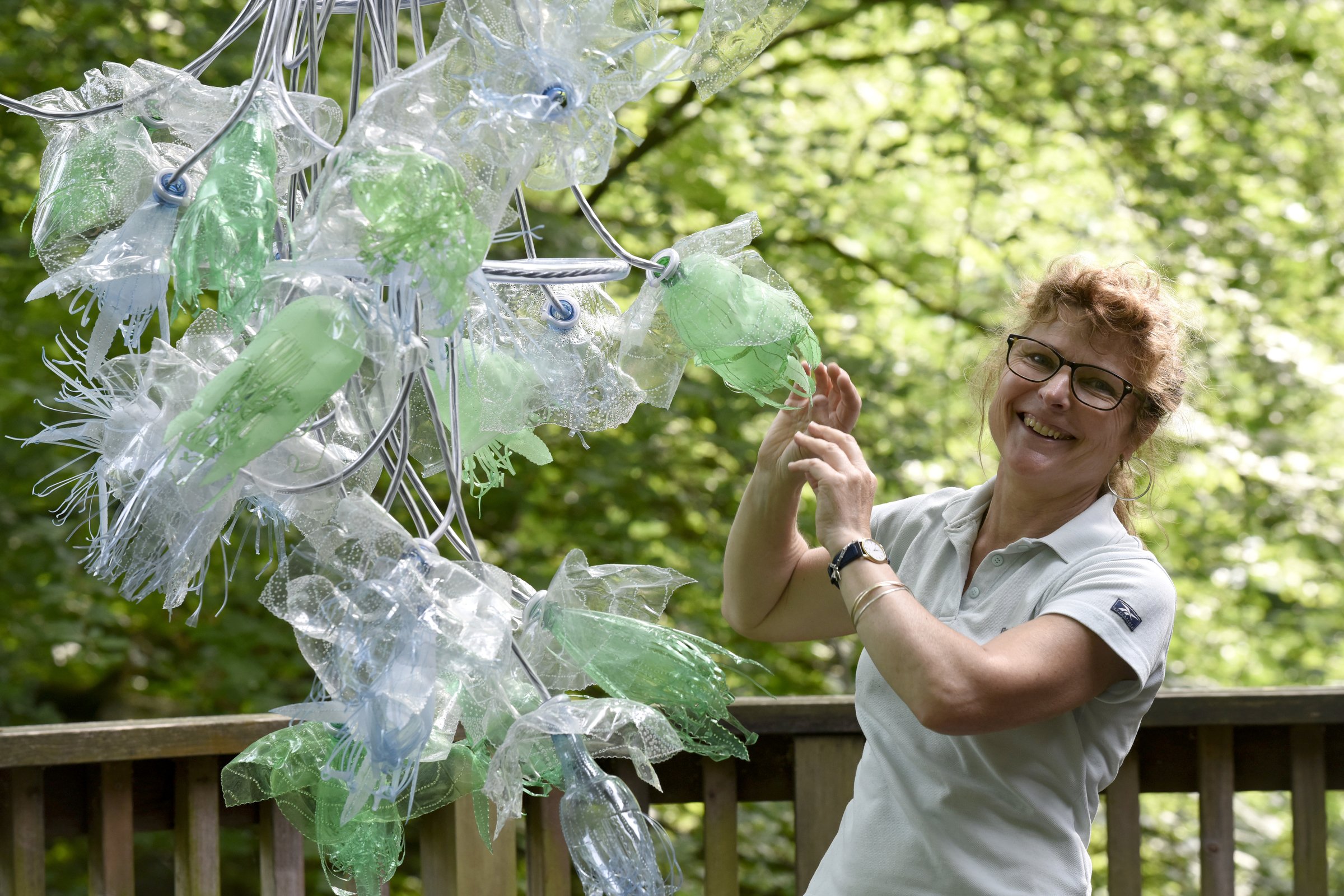 Artist Trudi Lloyd-Williams with her recycled bottle chandelier.