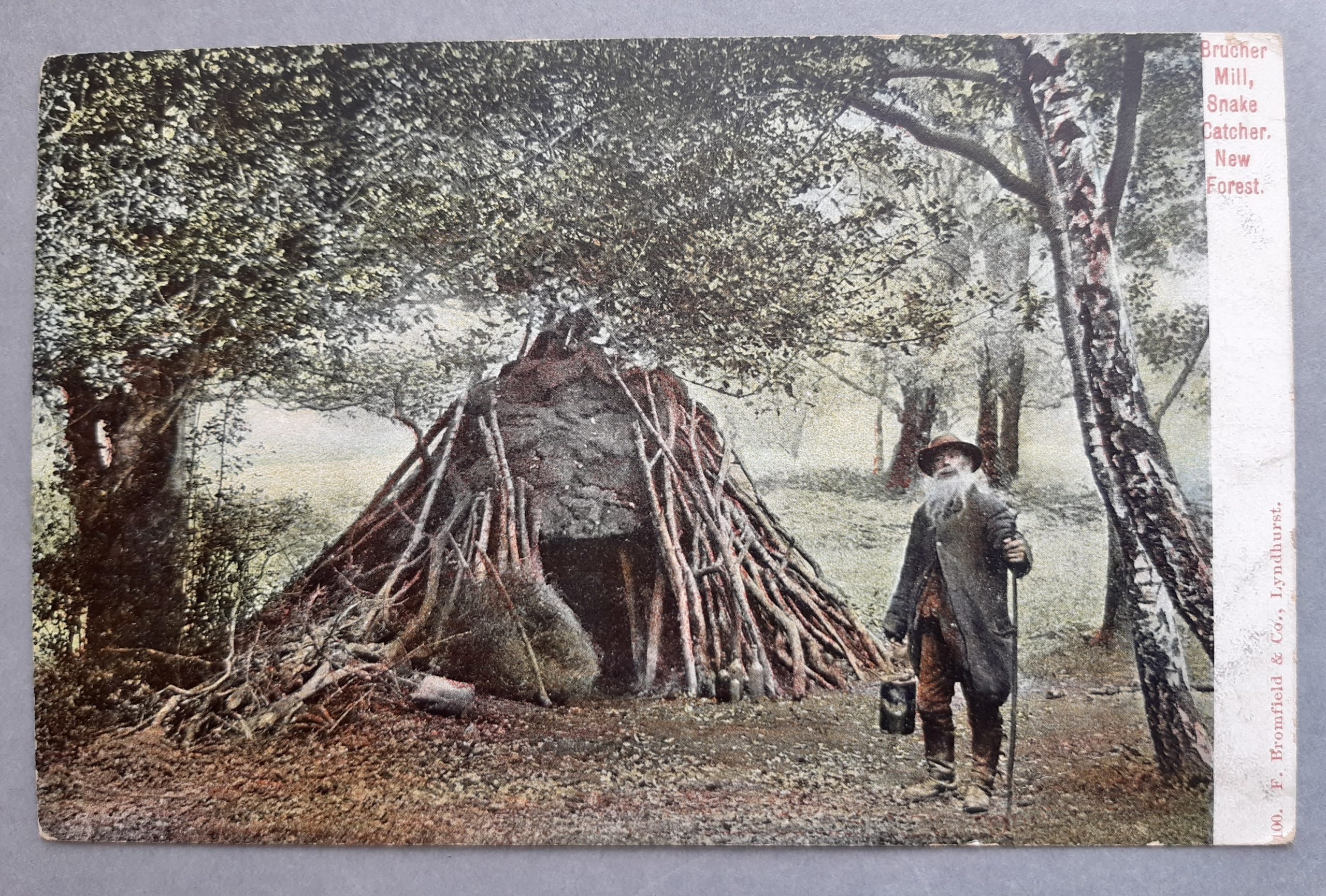 An old photograph of Brusher Mills next to a den structure in the Forest