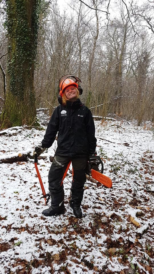 Former apprentice ranger Hayden stood in a snowy woodland with forestry tools and a helmet