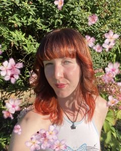 New Forest Youth Board member Rachel in front of flowers