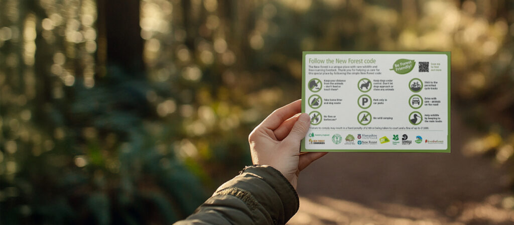 A person's hand hold out the New Forest code.