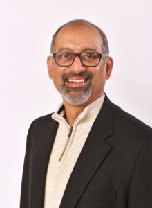 head & shoulders of a man in a navy jacket and cream jumper