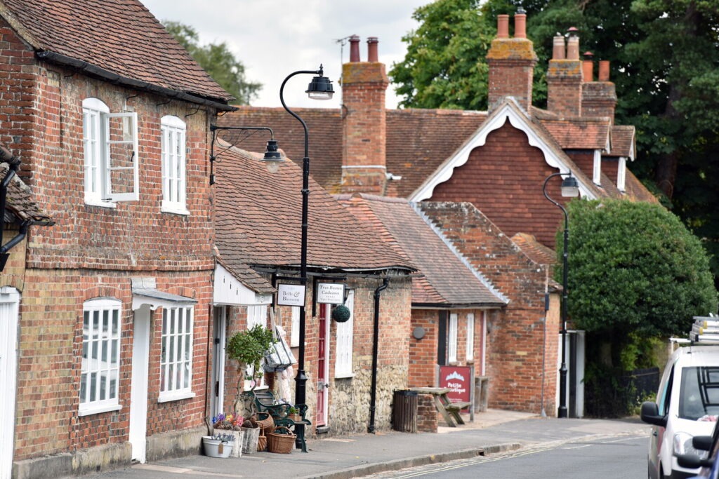 A row of brick homes and shops some with goods outside