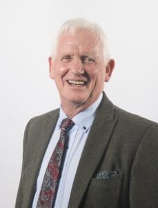 head & shoulders of a man in a grey jacket and tie