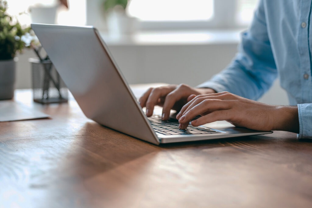 Hands of young contemporary office manager over laptop keypad during work