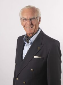 head & shoulders of a man in a blue jacket and cravat
