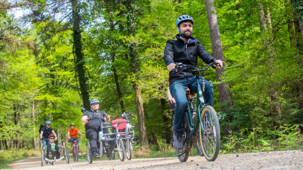 five people on bikes some of them recumbent on a pathway among trees