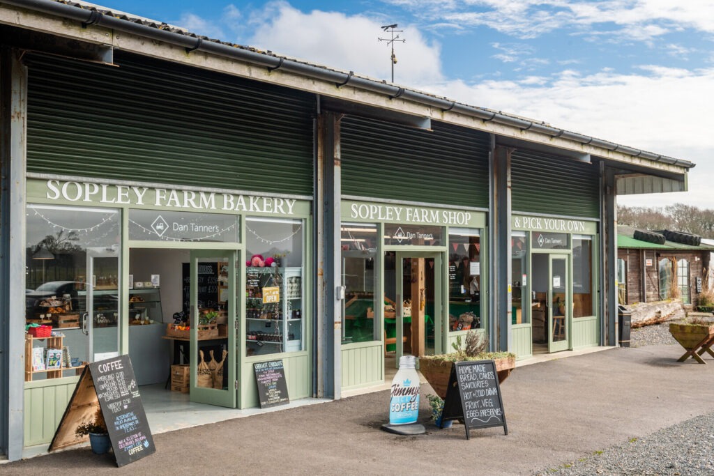a farm shop with three doors and signs outside