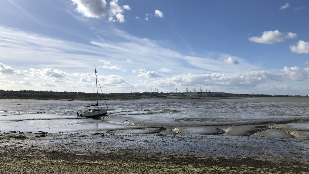 a sailing boat resting on mud at low tide