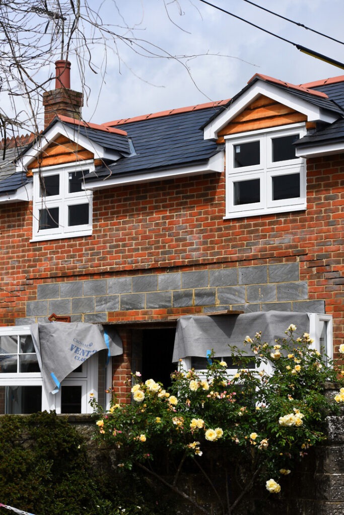 two homes being built with yellow flowers in front