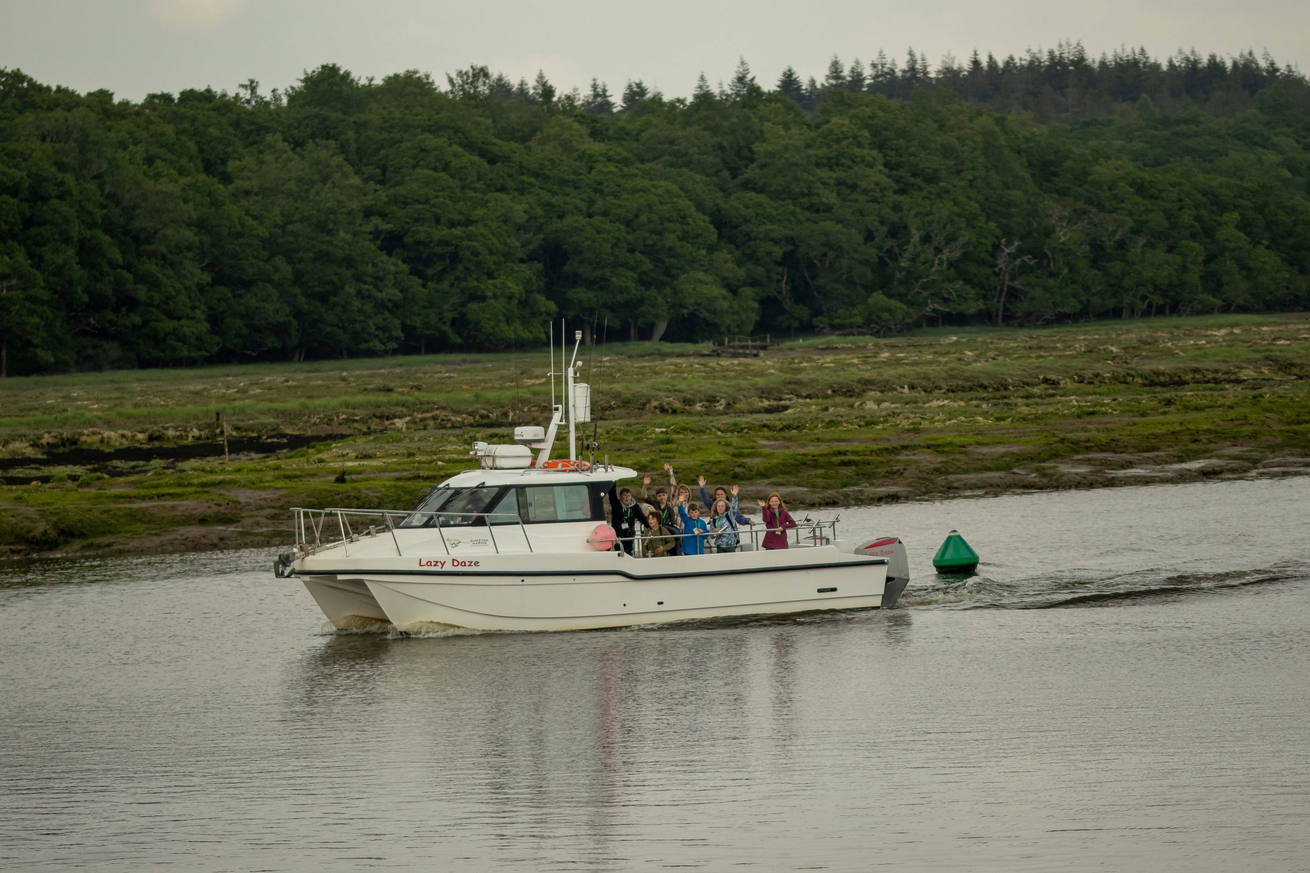 A group of young people on a small boat in the New Forest