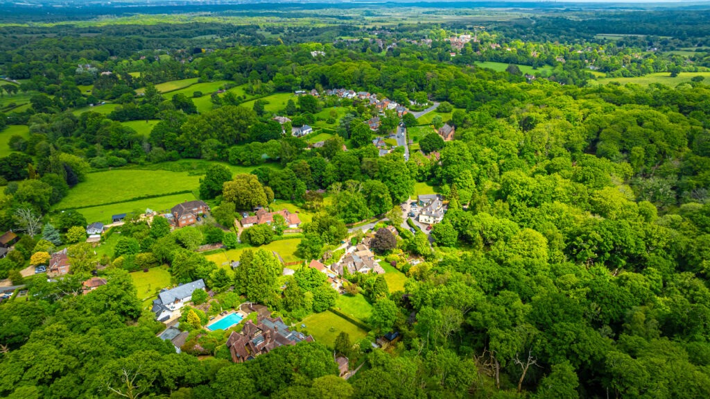 Aerial view of a small English village surrounded by trees