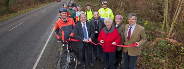 a group of people with bikes and a ribbon