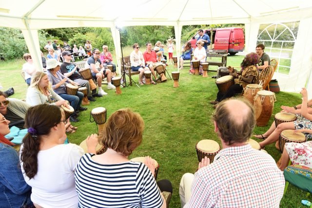 people sitting in a tent in a circle drumming