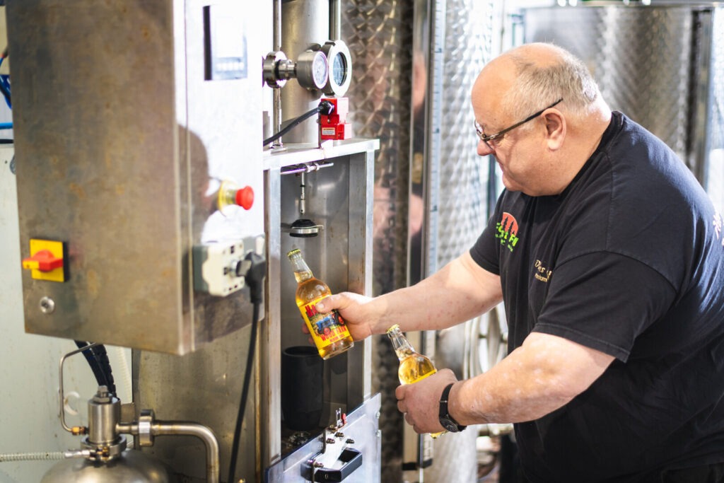 Man in a brewery holding cider bottle