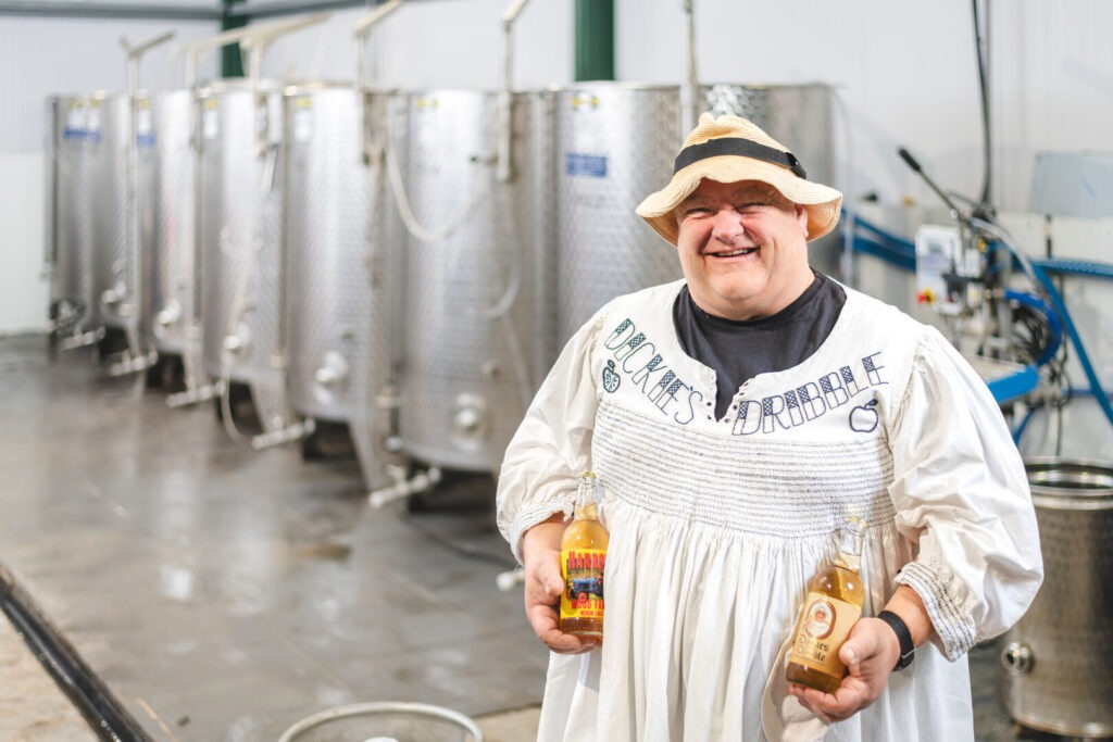 Man holding two cider bottles in a brewery