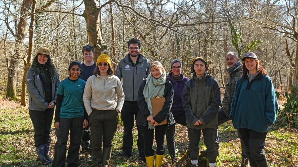 a group of young people standing in a wood