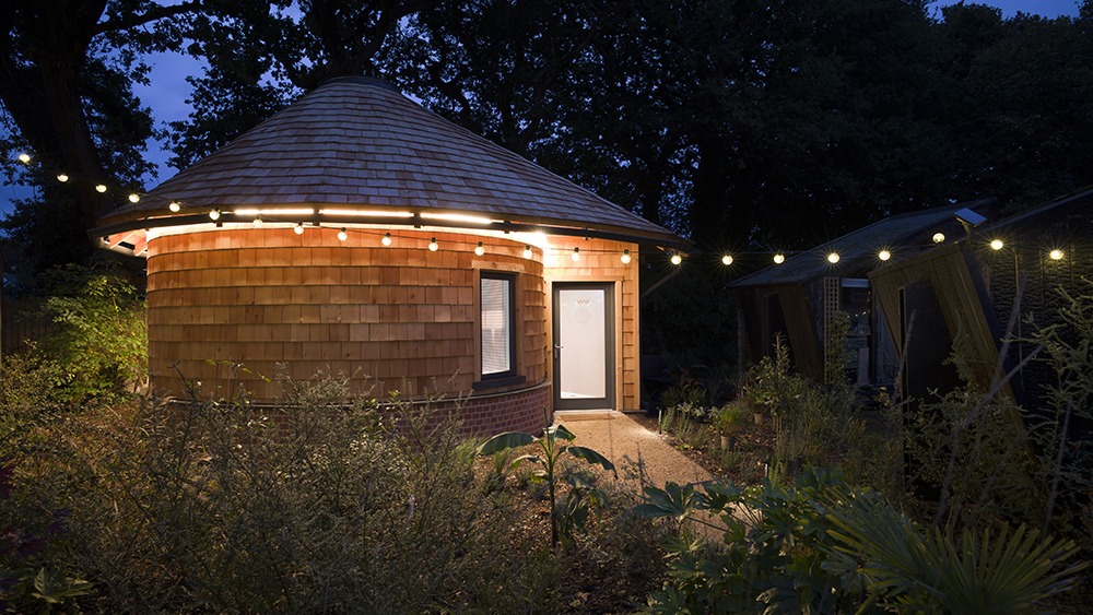 round small building at night, lit up with string lights