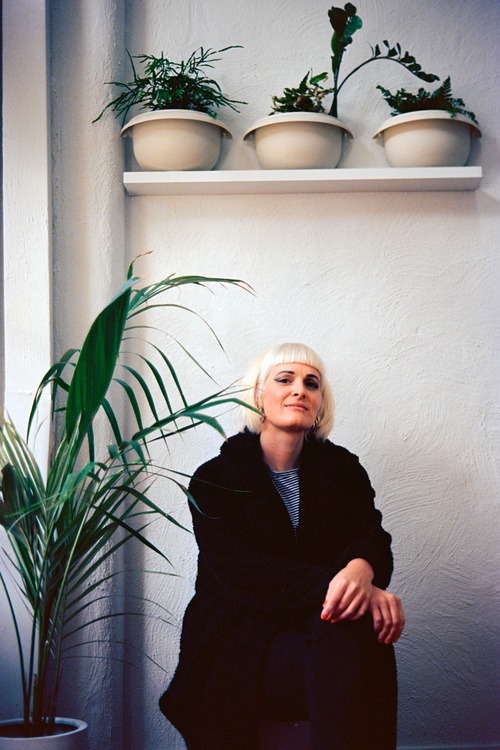 Woman sitting posed next to a plant