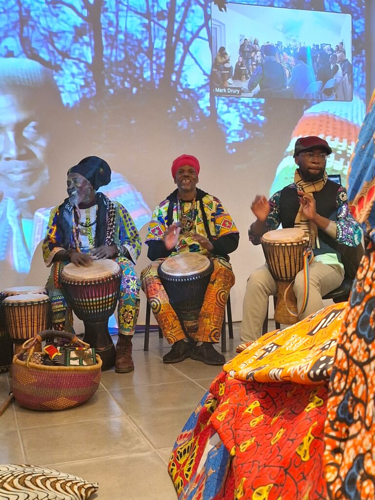 Three people in African dress drumming