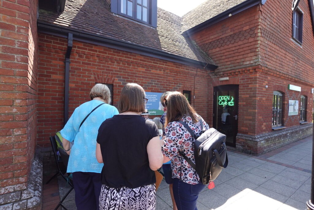 Three people stand outside a building in Lyndhurst as part of a Health and Heritage Group.