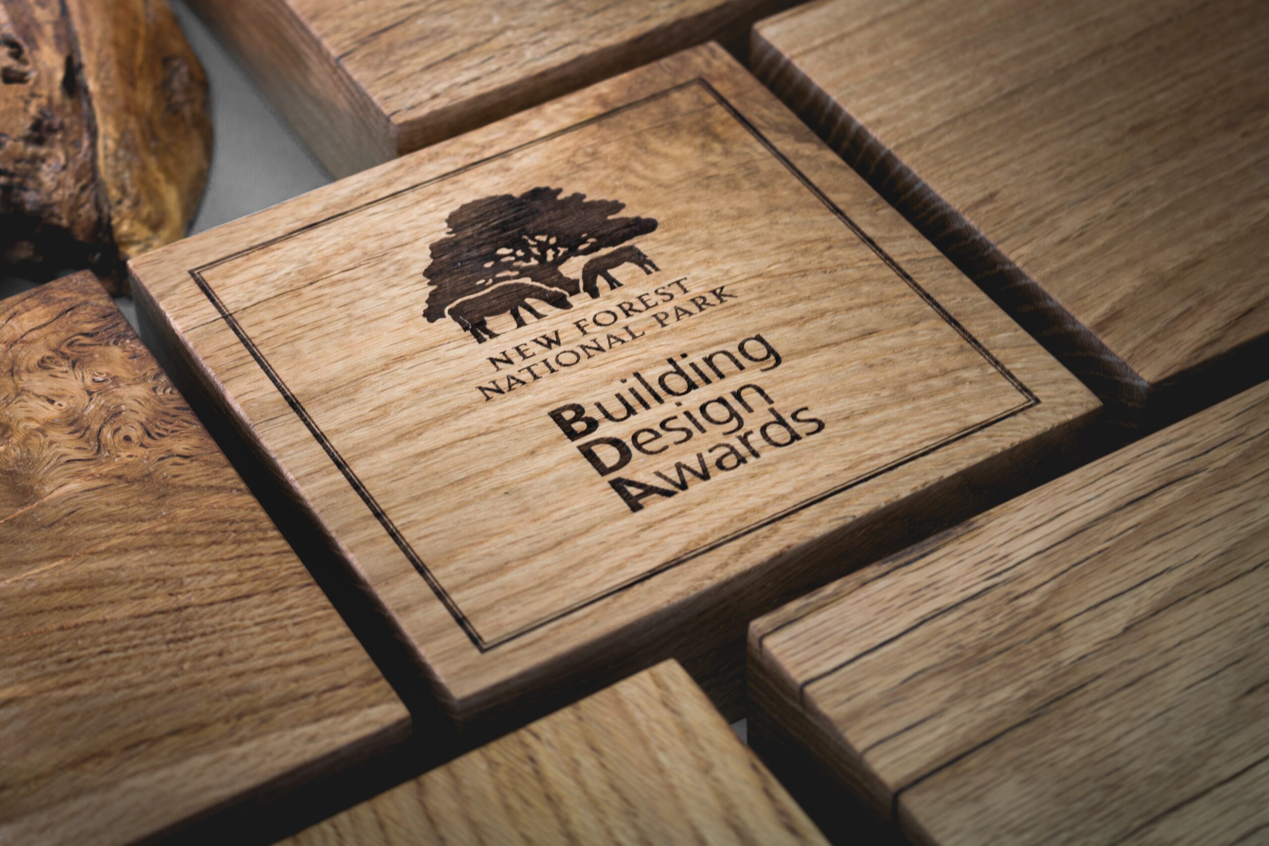Engraved oak award plaque reading New Forest National Park Building Design Awards, surrounded by wooden blocks