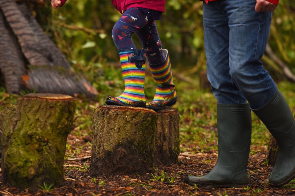 a child wearing wellies balancing on a log