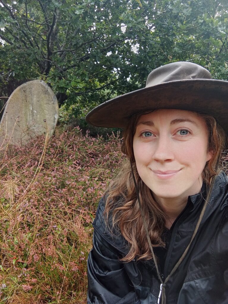 Woman in a hat standing in grass