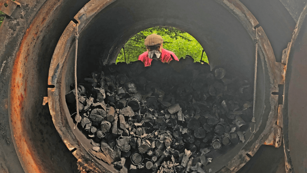 Man in a mask looking through a charcoal maker