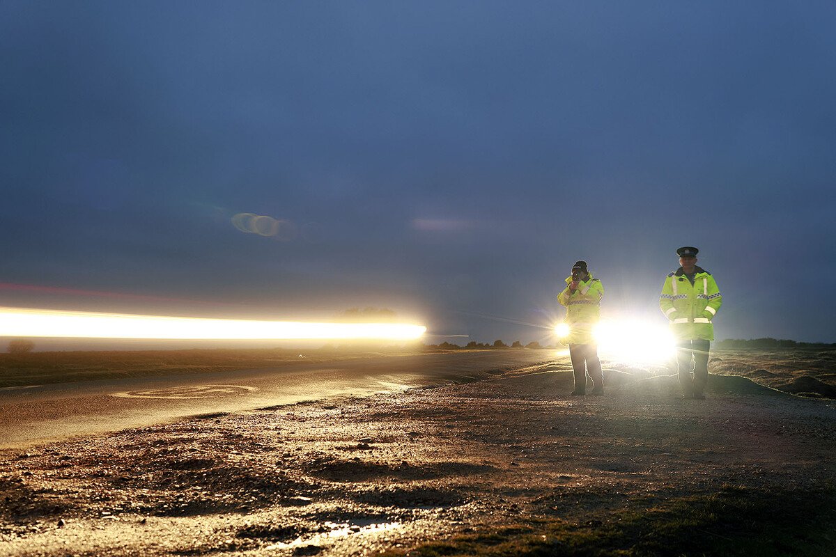 police in high vis on road at dusk