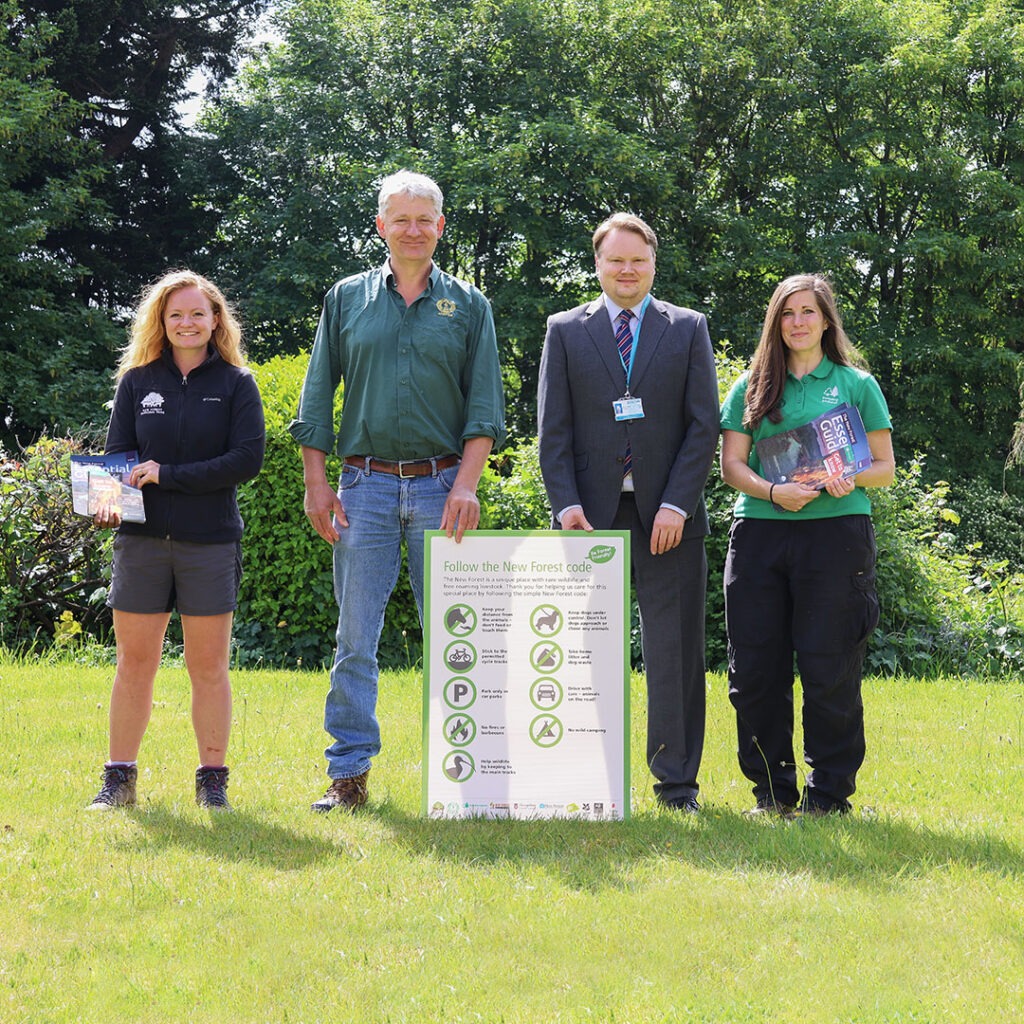 Group of people outside with a sign of the New Forest Code