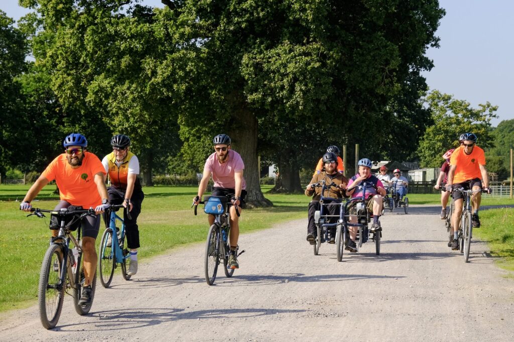 Cyclists ride along a New Forest track at New Pak near Brockenhurst with trees and greenery in the background