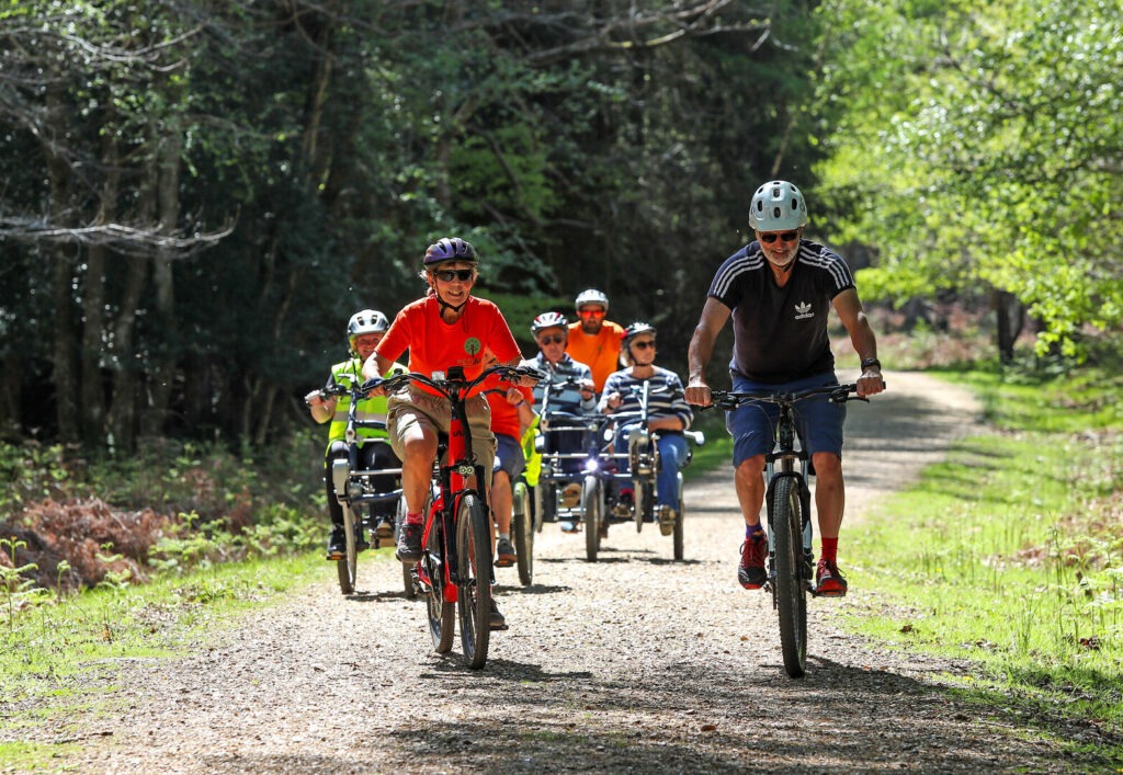 Group of cyclists on a New Forest track at the PEDALL inclusive cycling event in National Park.