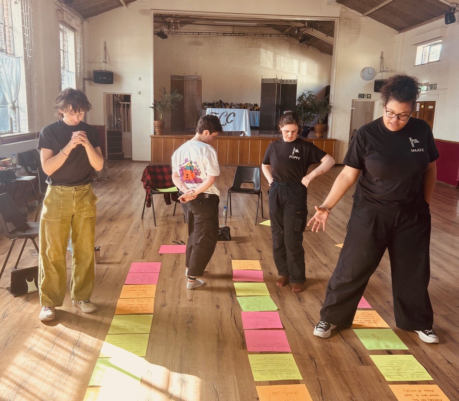 Theatre for Life cast in a rehearsal session for Bringing the Outside In from left to right: Ri Baroche (she / they), Kit Miles (they / them), Poppy Lowles (she / her), and Imani Okoh (she / her)