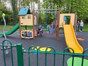 Children playing on rope net and slides at Queen Elizabeth II play area, Wharton’s Lane, Ashurst