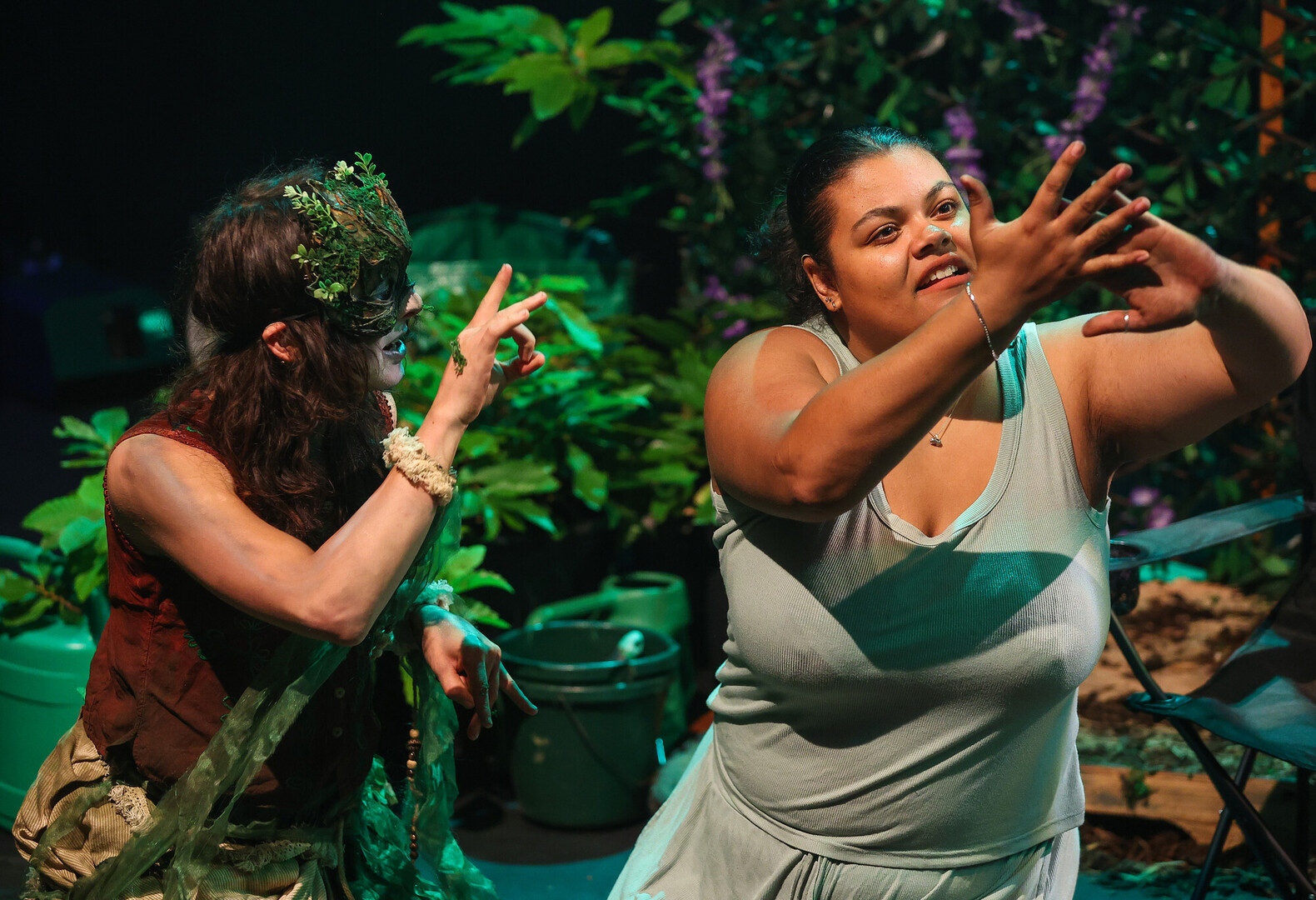 Two actors on stage during the debut show of Bringing the Outside In in Southampton. The pair are in costume and interacting with each other looking up from the stage.