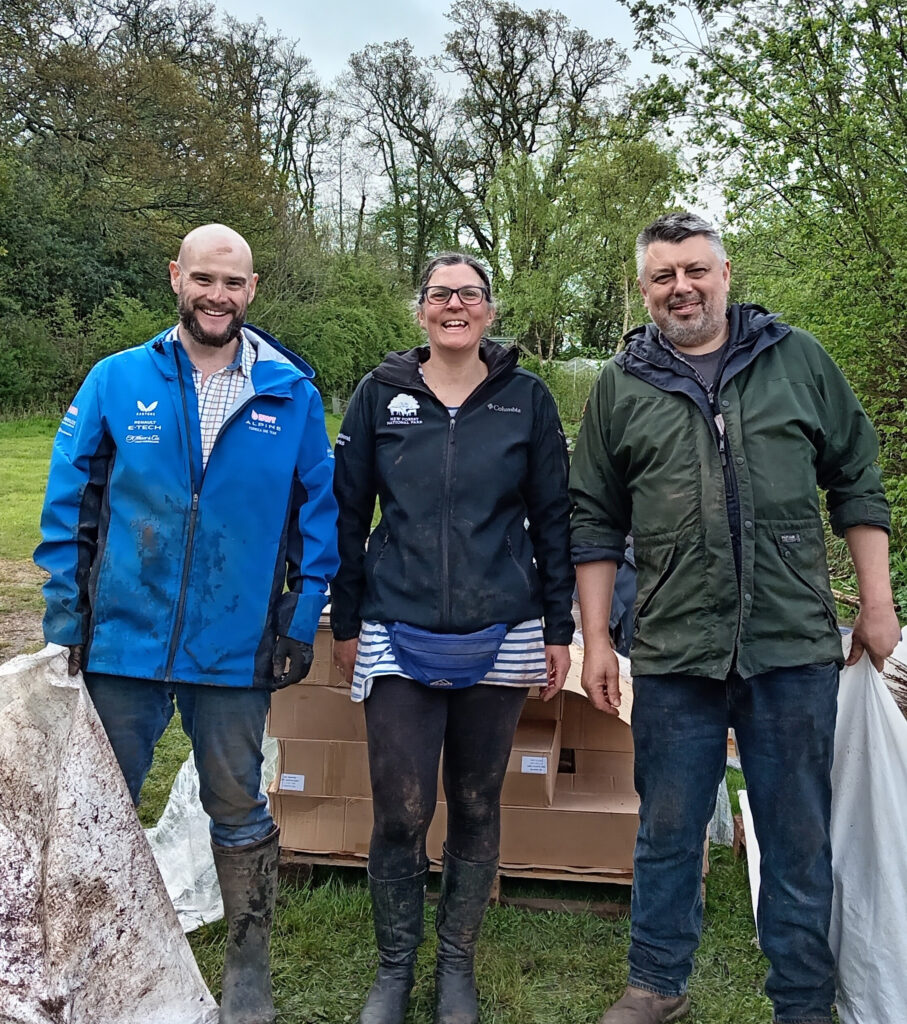 Sam Loades, Julie Prior and Rhys Morgan of New Forest Land Advice Service standing outdoors in muddy boots by cardboard boxes