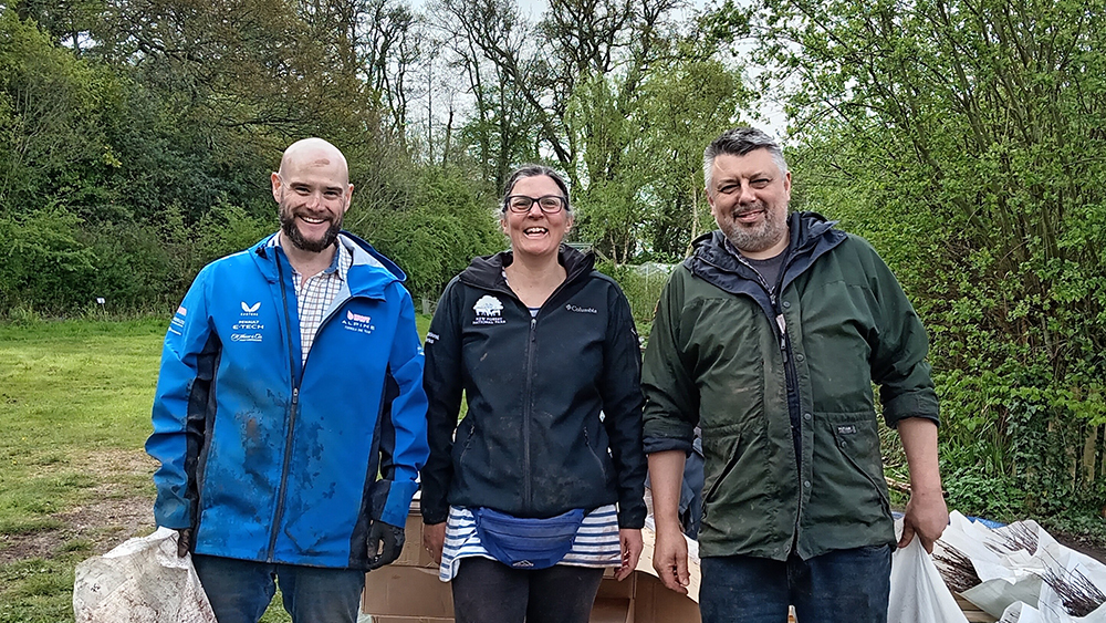 Sam Loades, Julie Prior and Rhys Morgan of New Forest Land Advice Service standing outdoors holding bags, smiling