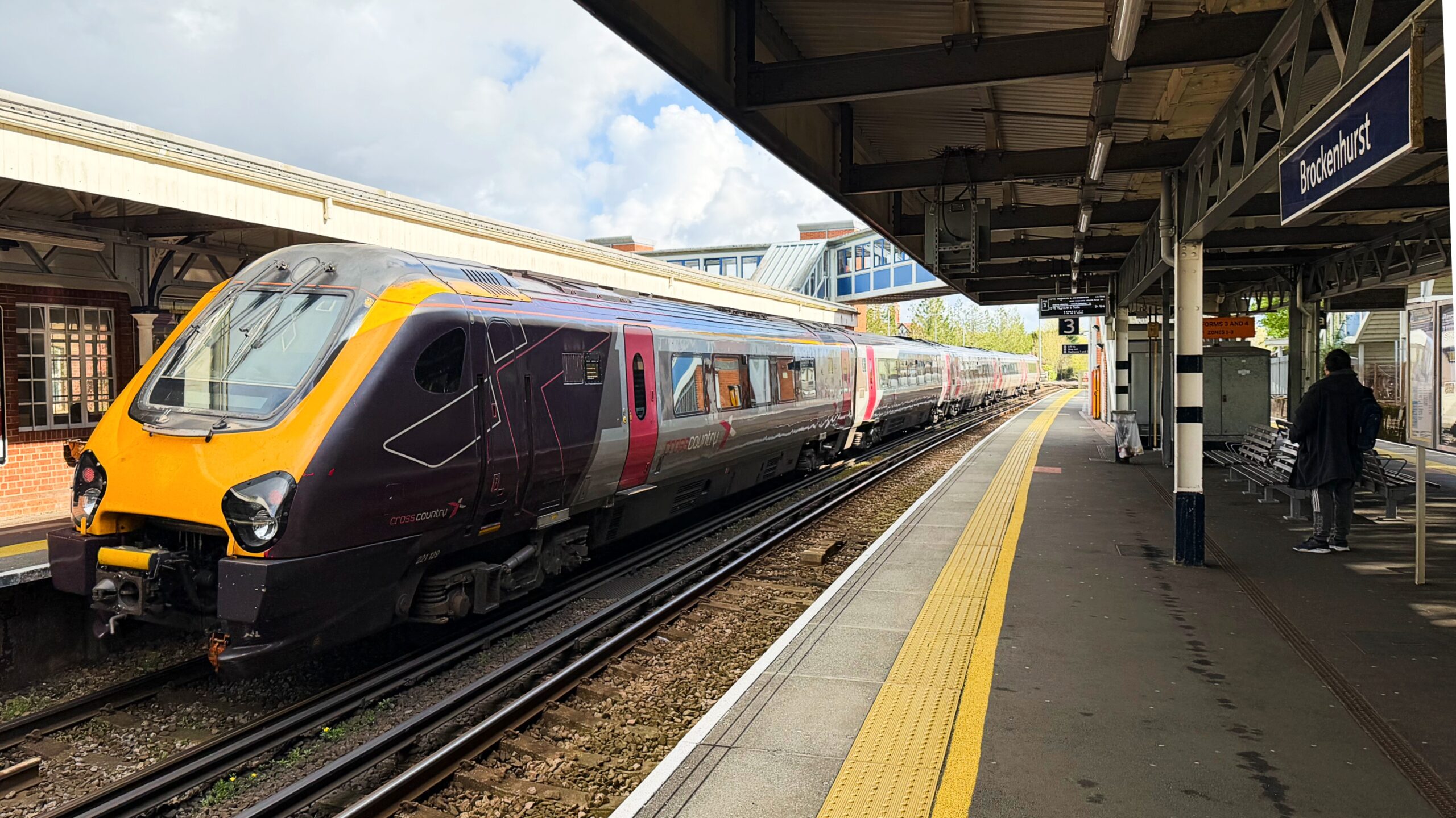 CrossCountry train standing at Brockenhurst station platform, with footbridge and station sign visible