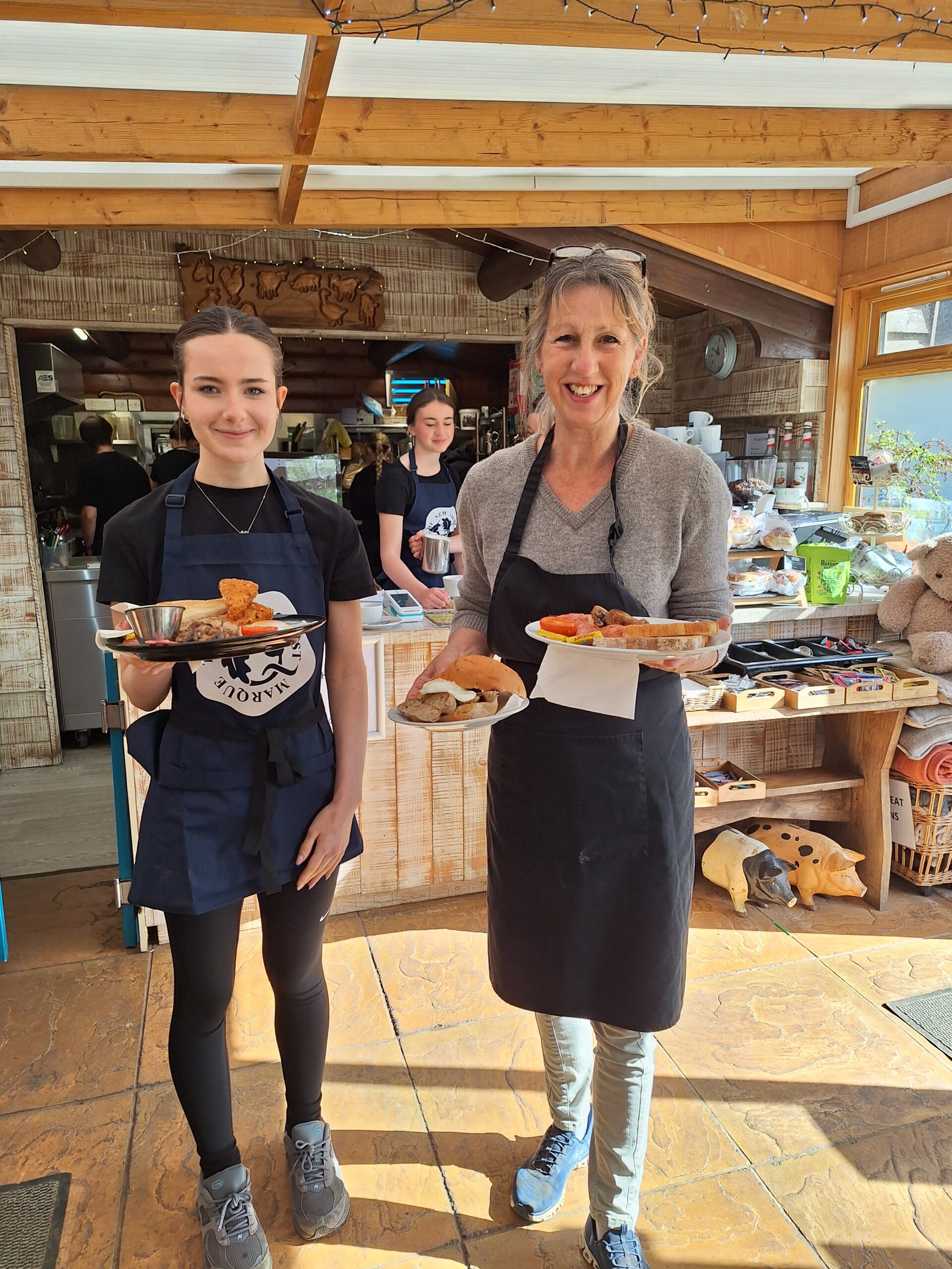 Two women in a cafe serving breakfast