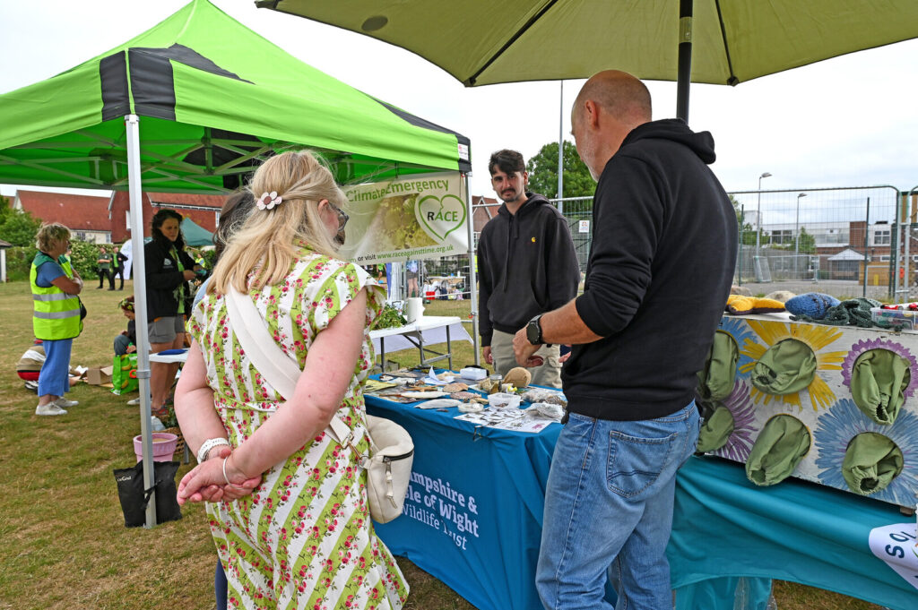 People interact with stallholders at New Forest Thrive festival.