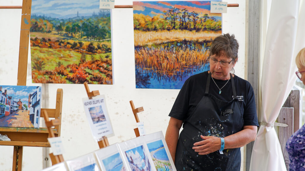Woman in apron surrounded by paintings