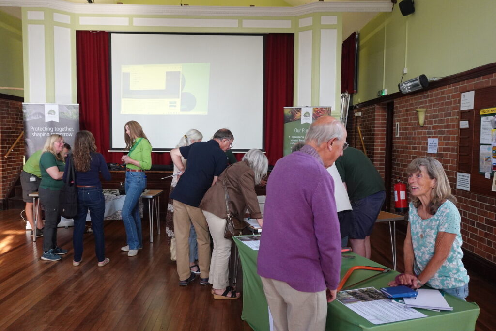 Members of the public stand by table and NPA staff at an open evening for the former Breamore Railway Line