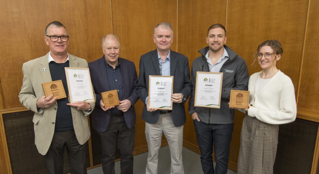 Five award winners holding framed certificates and wooden plaques at the New Forest National Park Authority Building Design Awards 2026